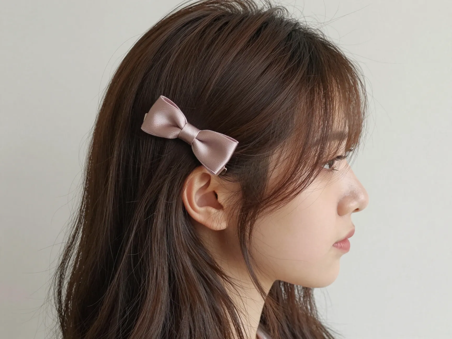 Side swept hair with mini bow clip near ear effortless look