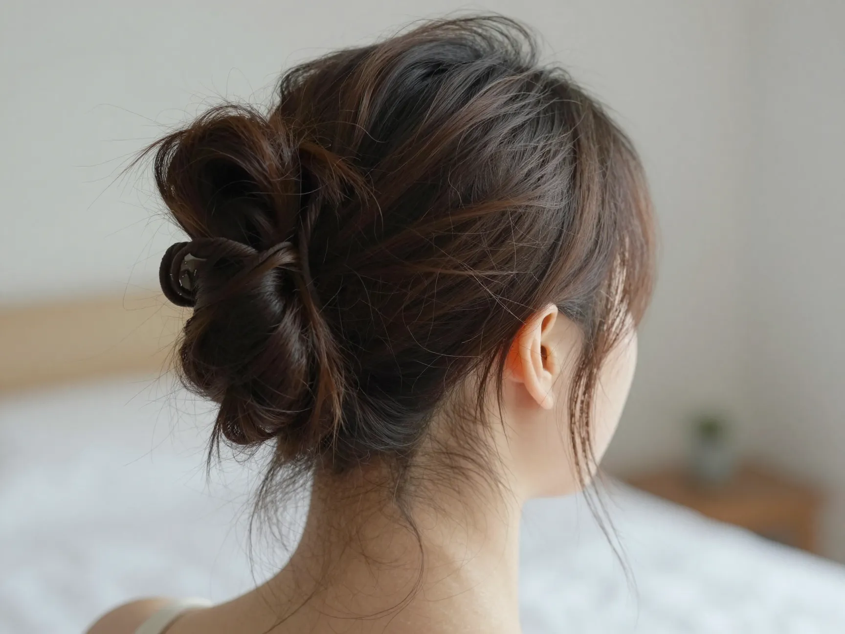 Low undone messy bun with loose face framing pieces