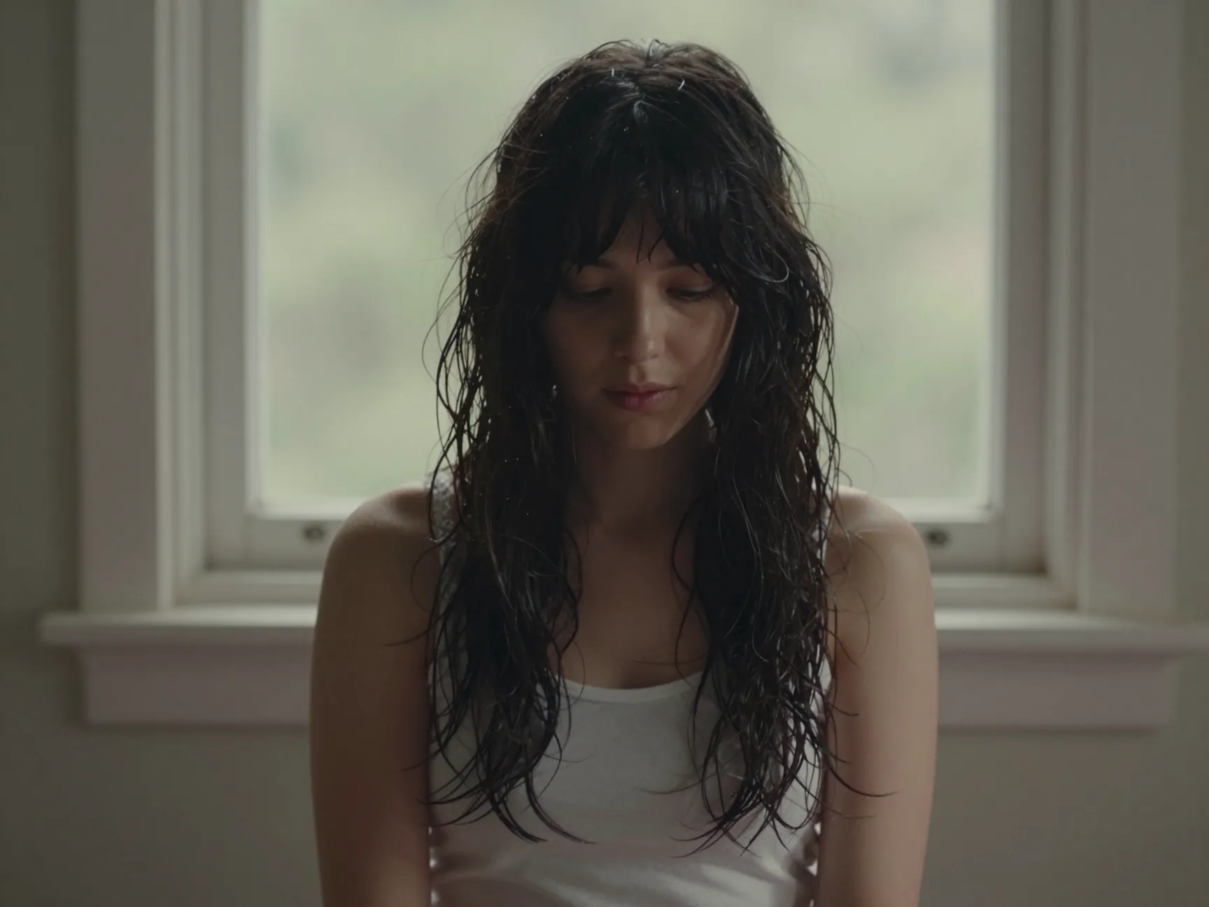 A person with shag cut curtain bangs air drying in natural light