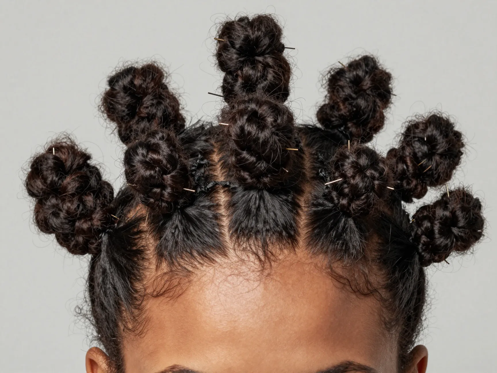 Sculptural bantu knots on curly hair sections coiled and secured