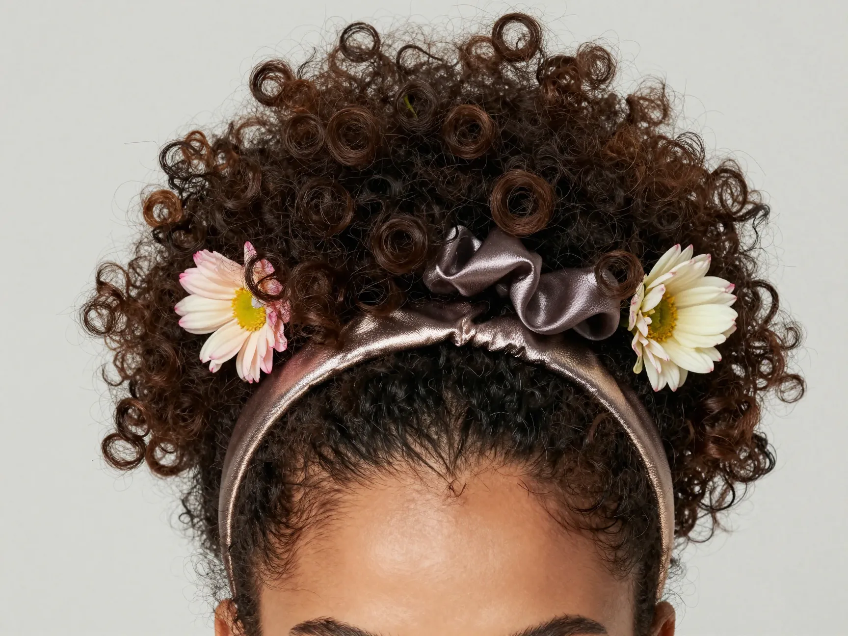High curly puff with metallic headband and fresh flowers