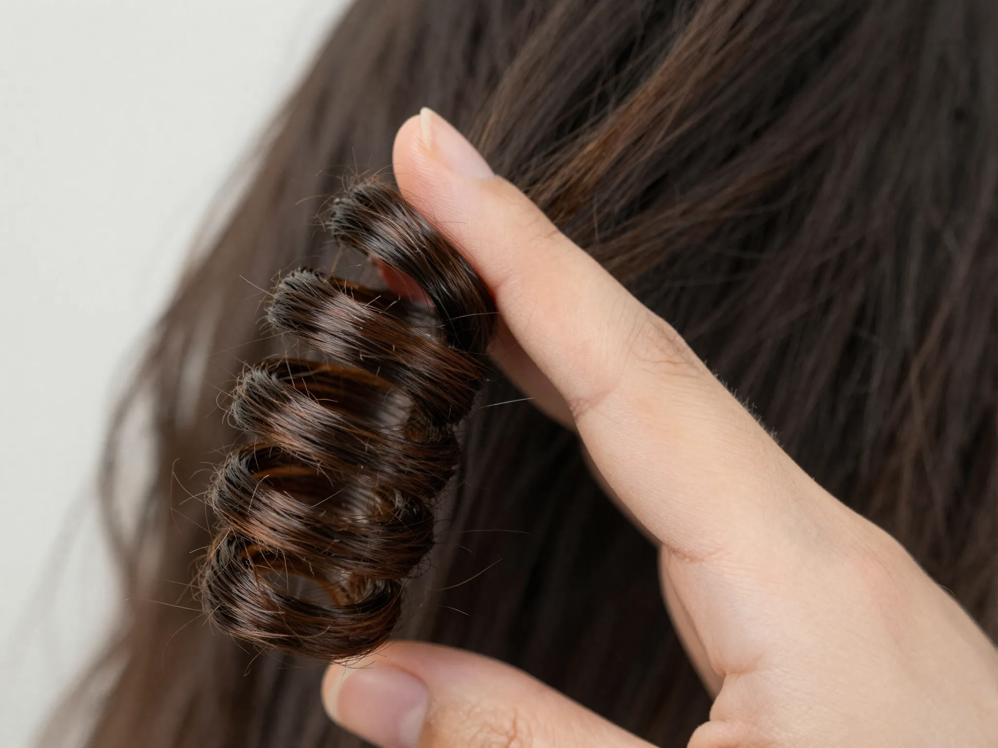 Finger coiling tight spiral on slightly damp curly hair