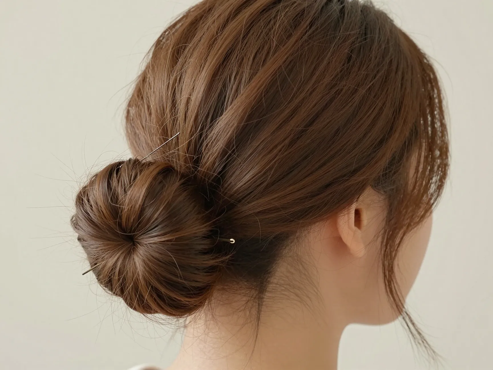 Undone low fold bun with bobby pins and face framing pieces