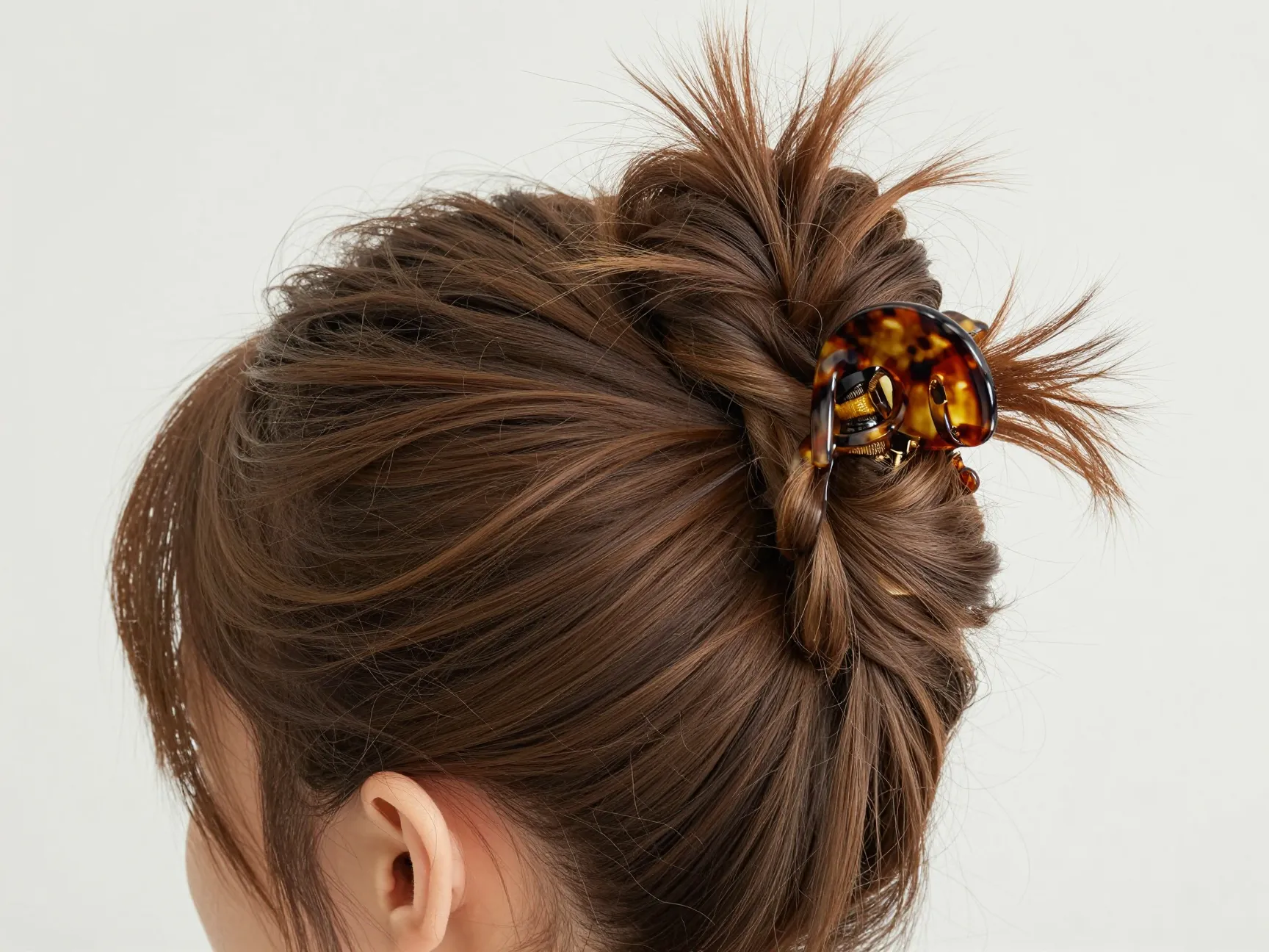 Effortless chic claw clip updo with twisted hair and fanned ends