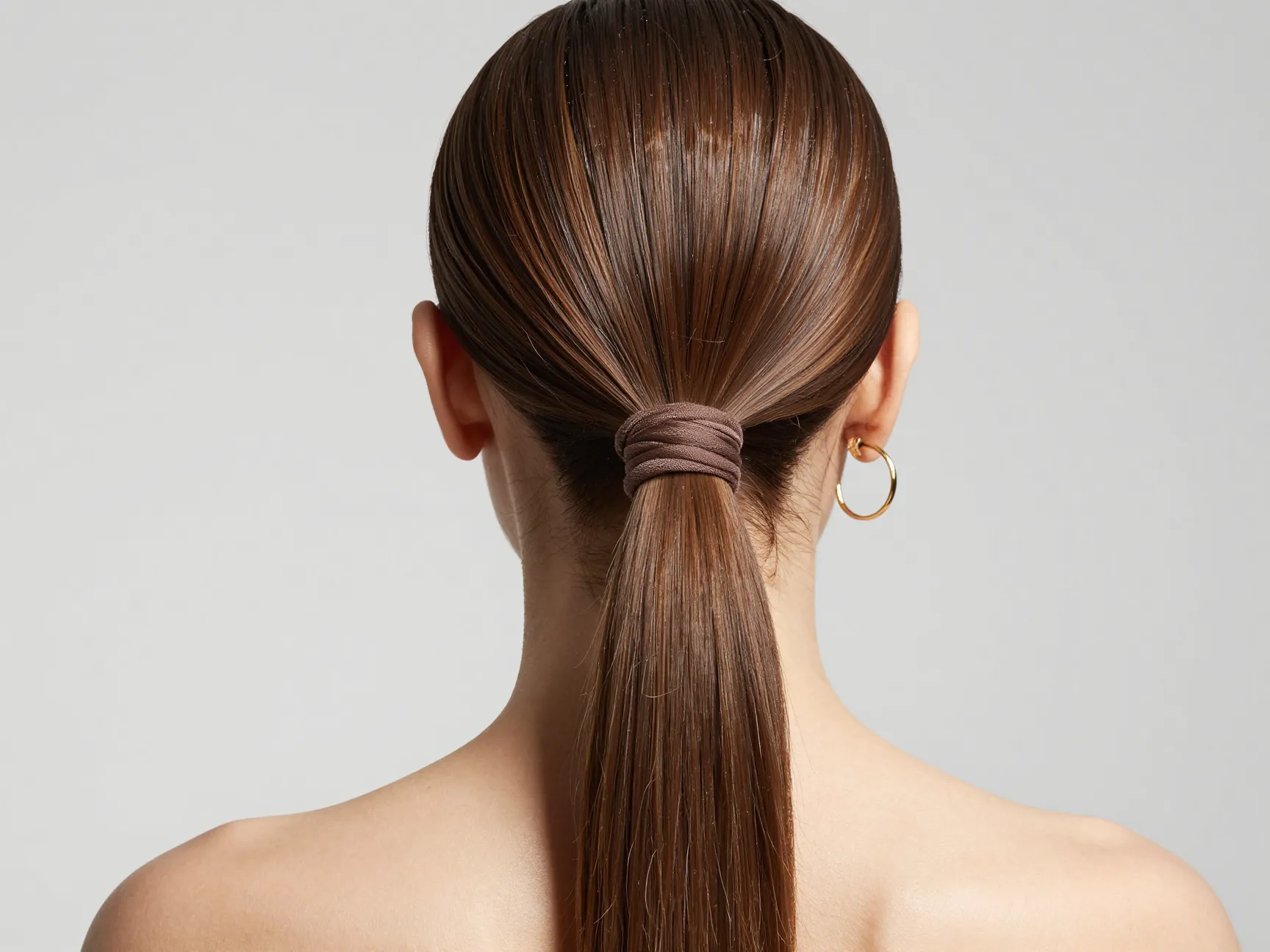 Low sleek ponytail with wrapped elastic