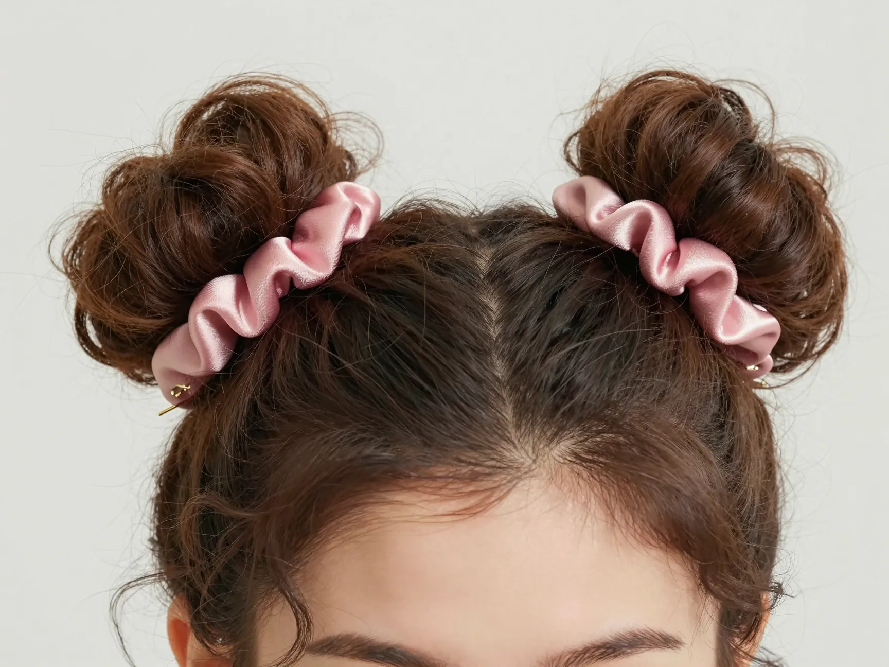 Double space buns on curly hair with high placement