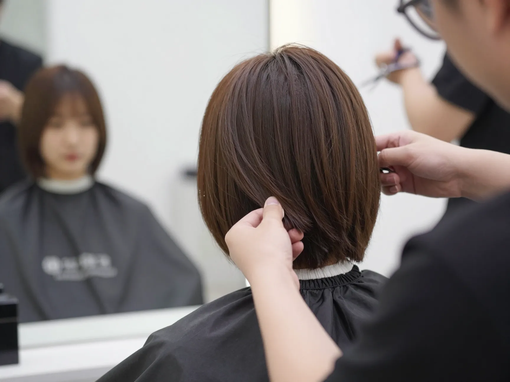 A stylist shaping the soft rounded layers of a cup cut bob