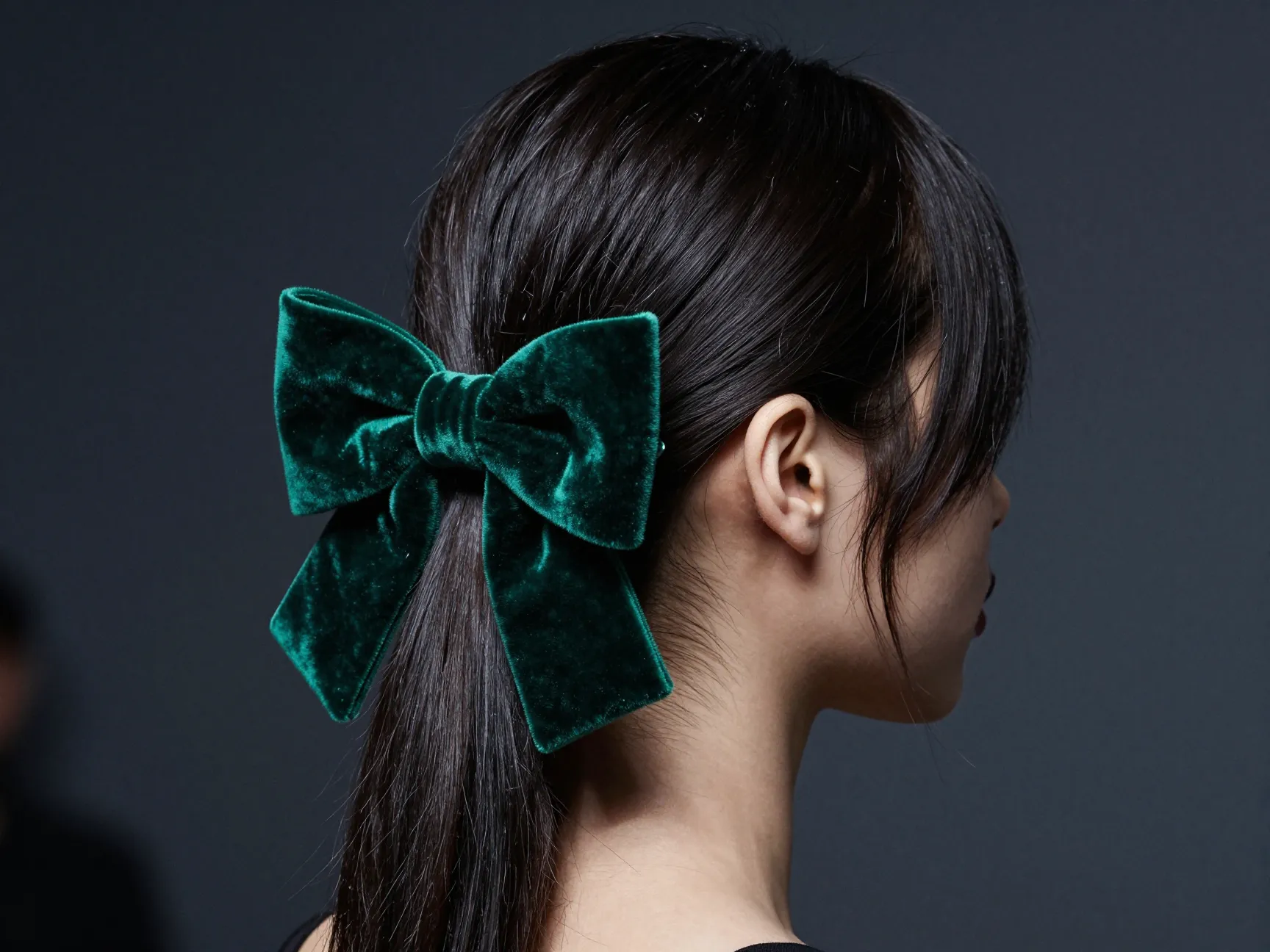 Asymmetrical side swept hair with emerald velvet bow