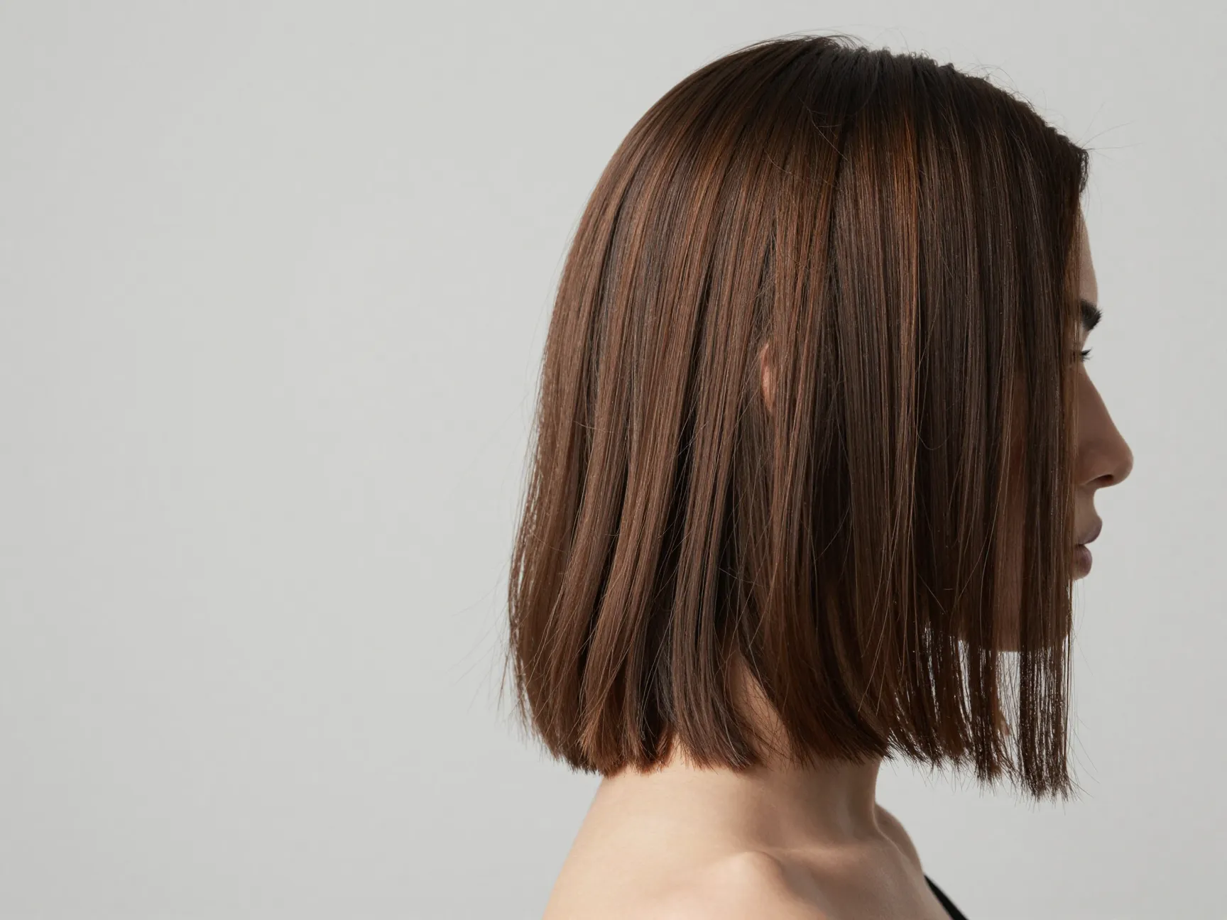 A side view of an angled lob with longer front strands grazing the collarbone