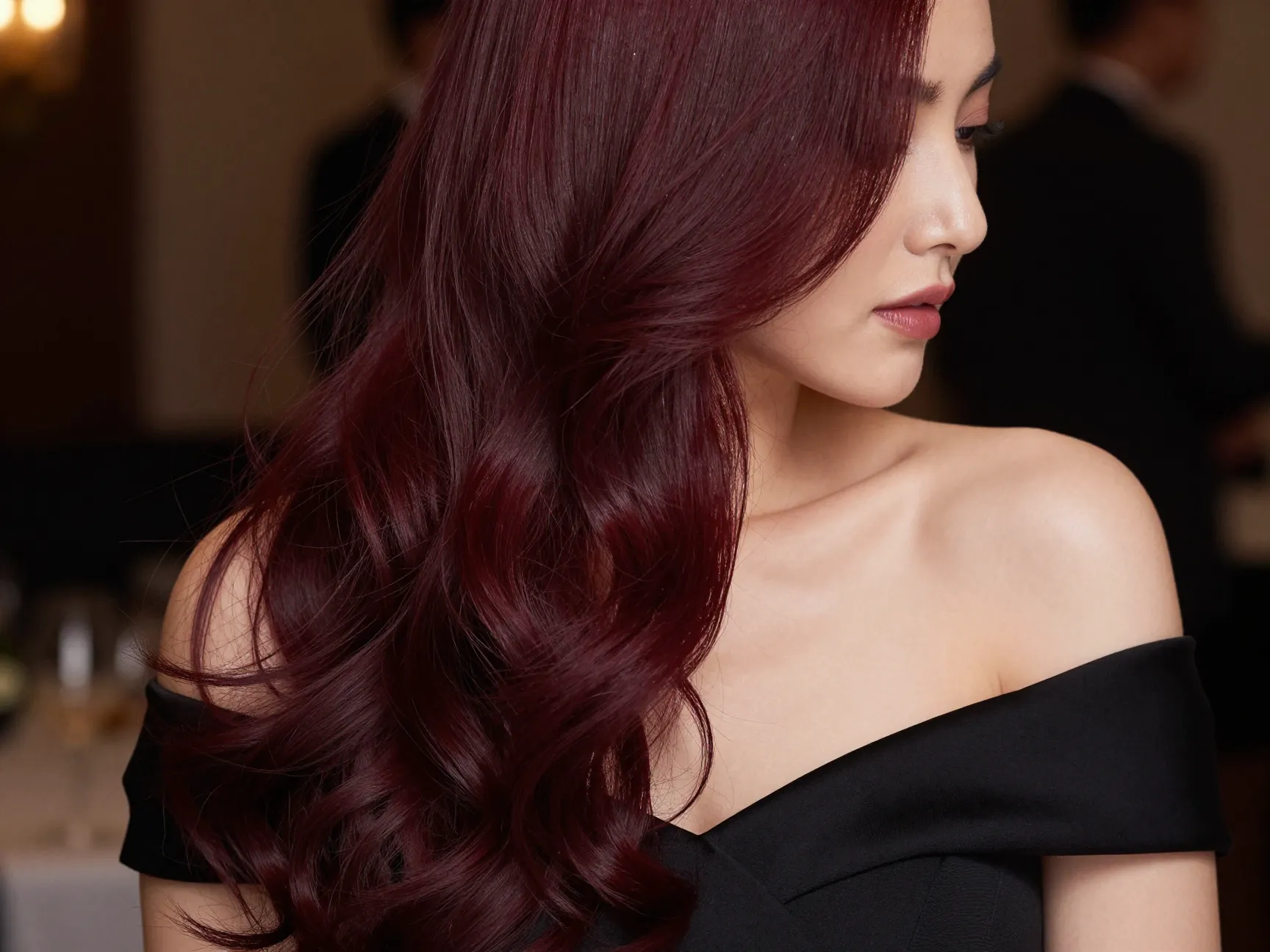 Glamorous deep burgundy hair under soft evening event lighting