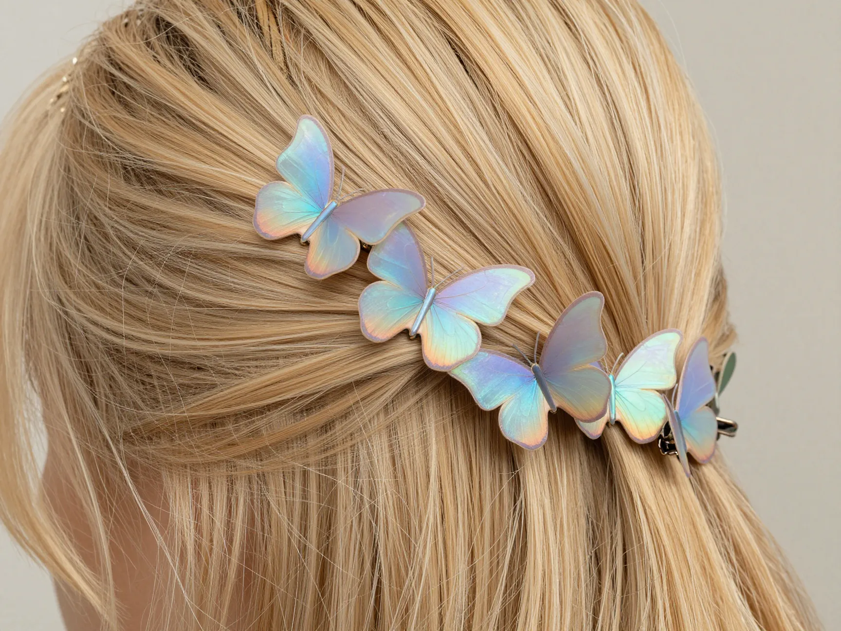 Cluster of iridescent butterfly clips on half up blonde hair