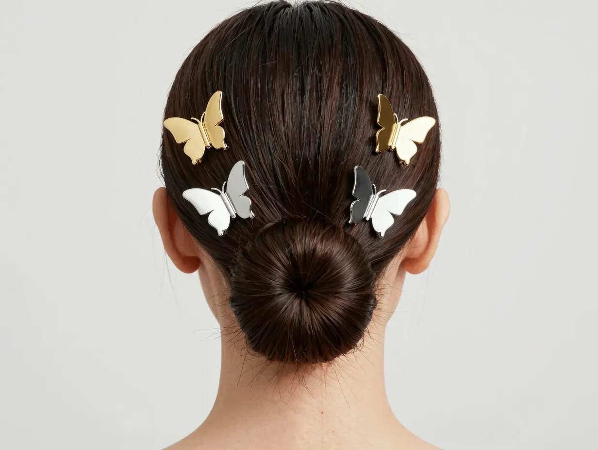 Mini metallic butterfly clips framing face on a low bun