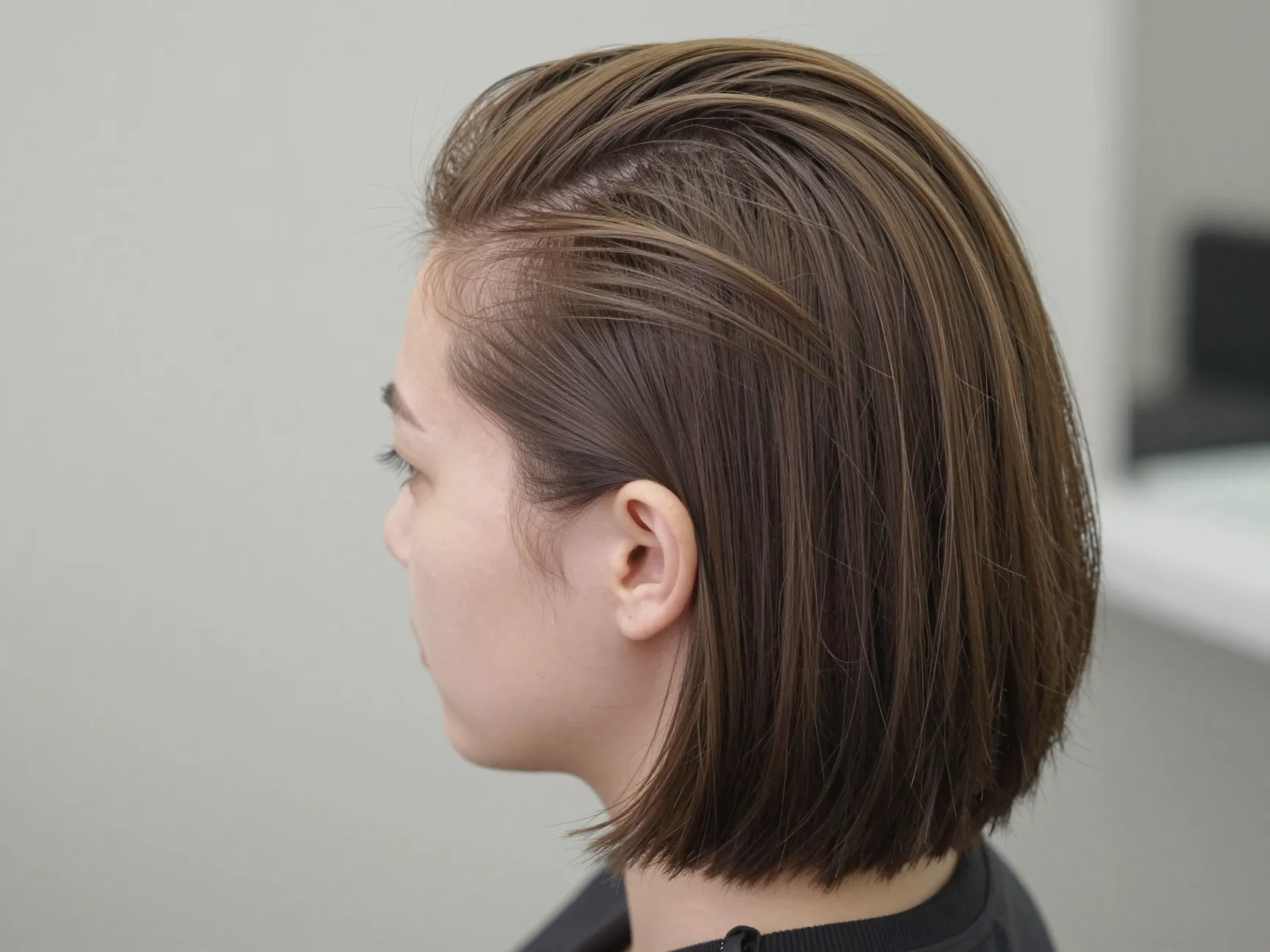 Deep side part slicked bob with textured ends and light pomade
