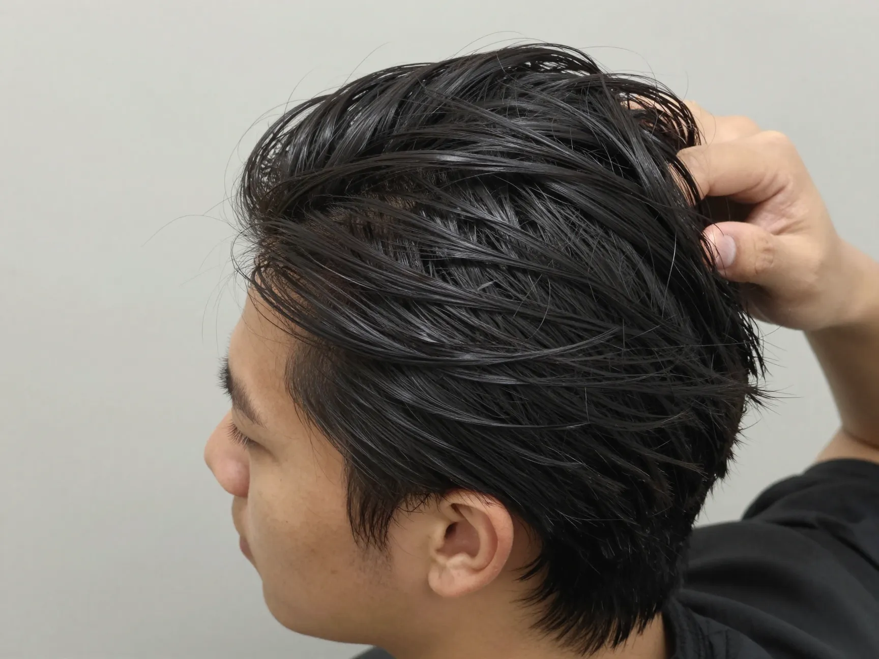 Messy slicked back hairstyle with loosened texture and matte finish