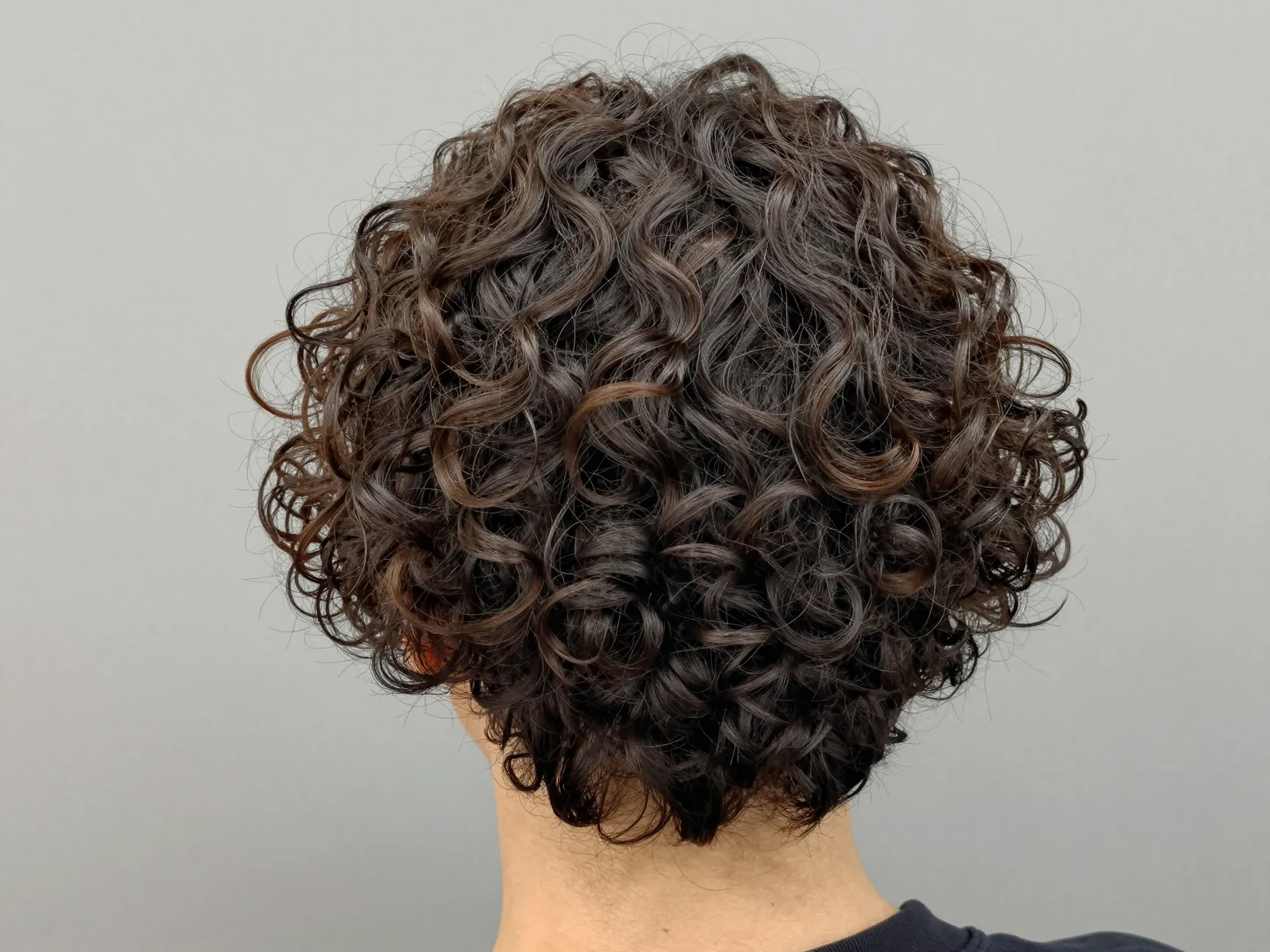 Short stacked curly cut rounded graduation crown volume backview