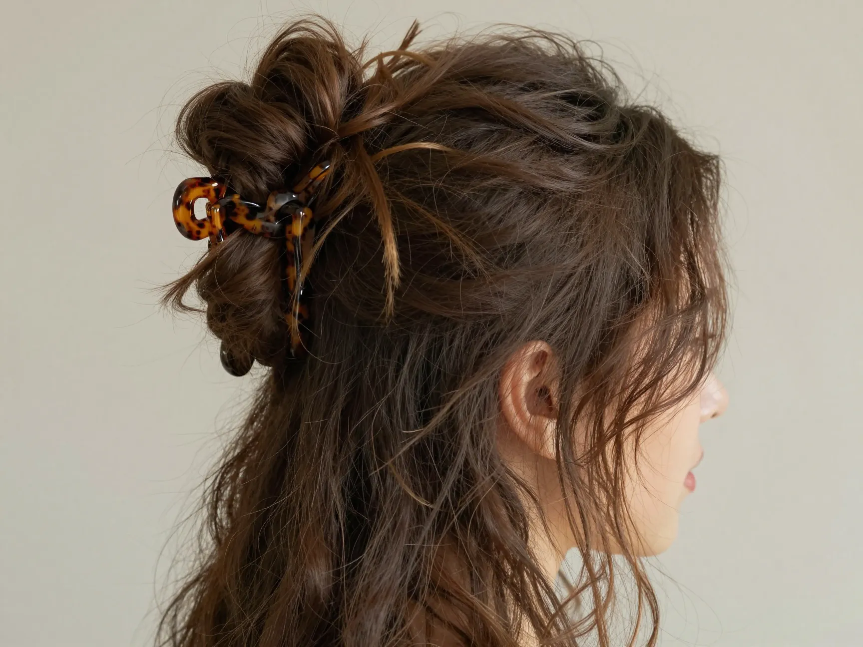 Messy bun half up hairstyle created with tortoiseshell claw clip
