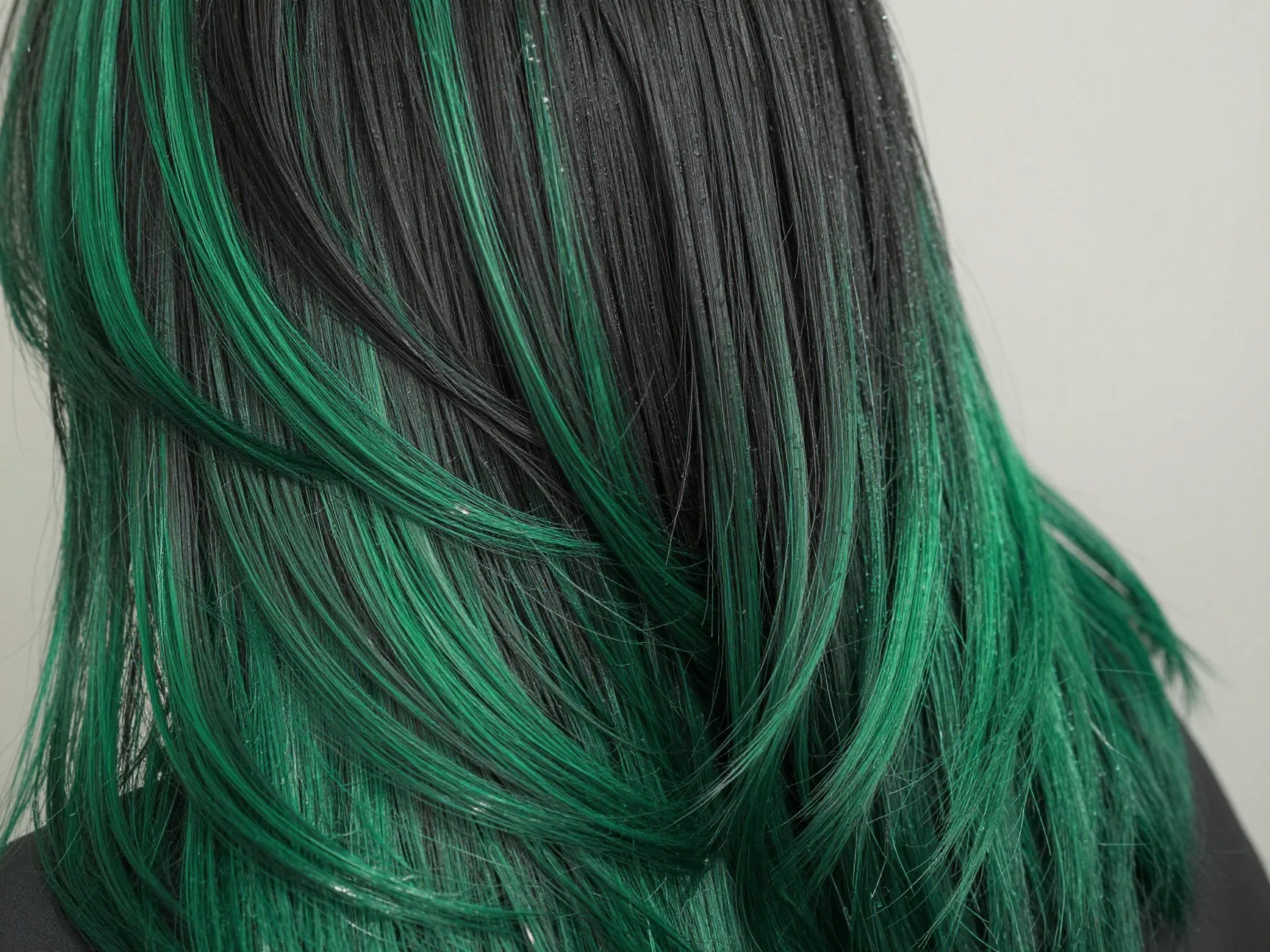 Emerald green balayage on black hair with glossy finish treatment