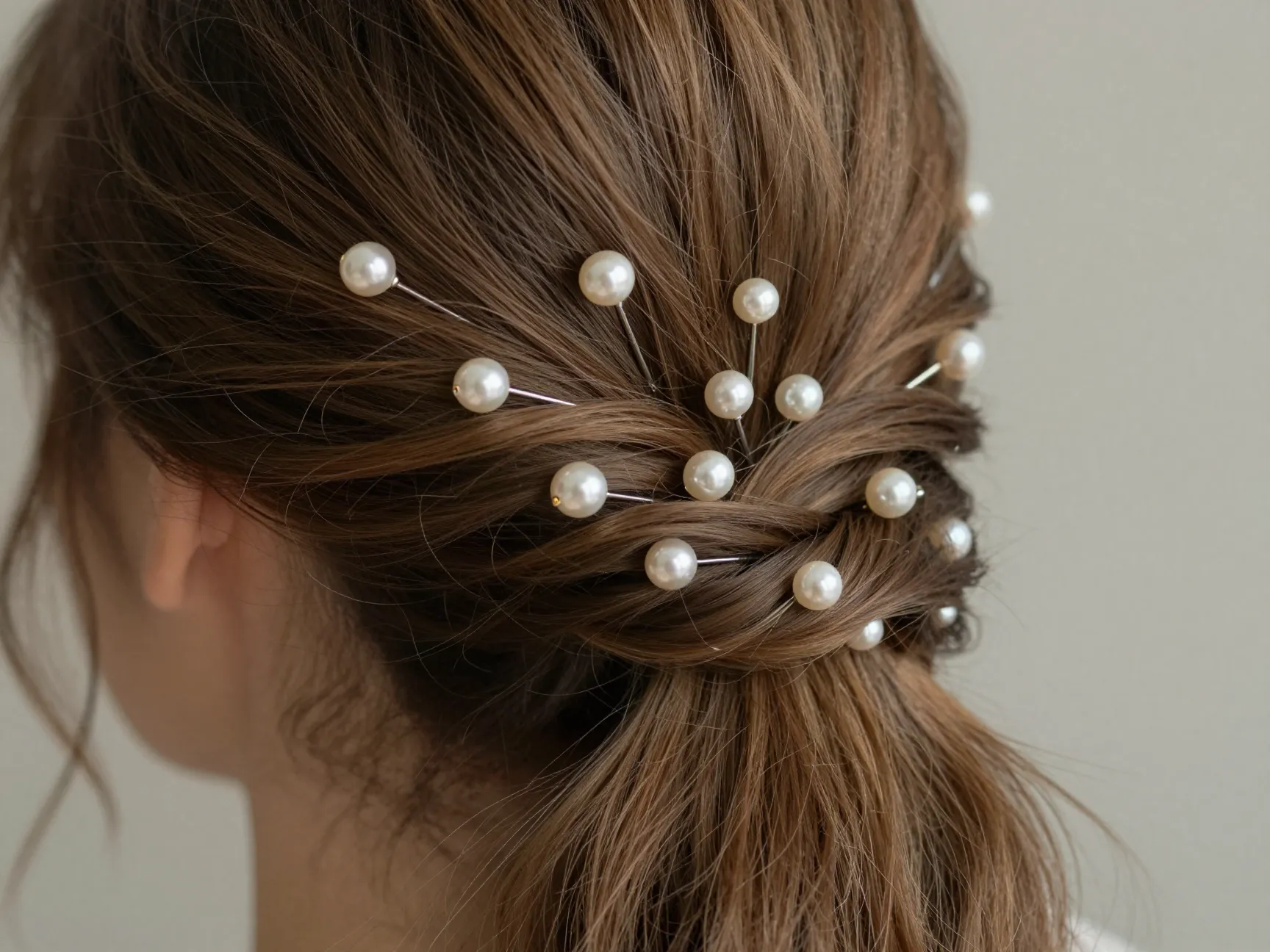 Simple half up hairstyle accessorized with scattered pearl bobby pins