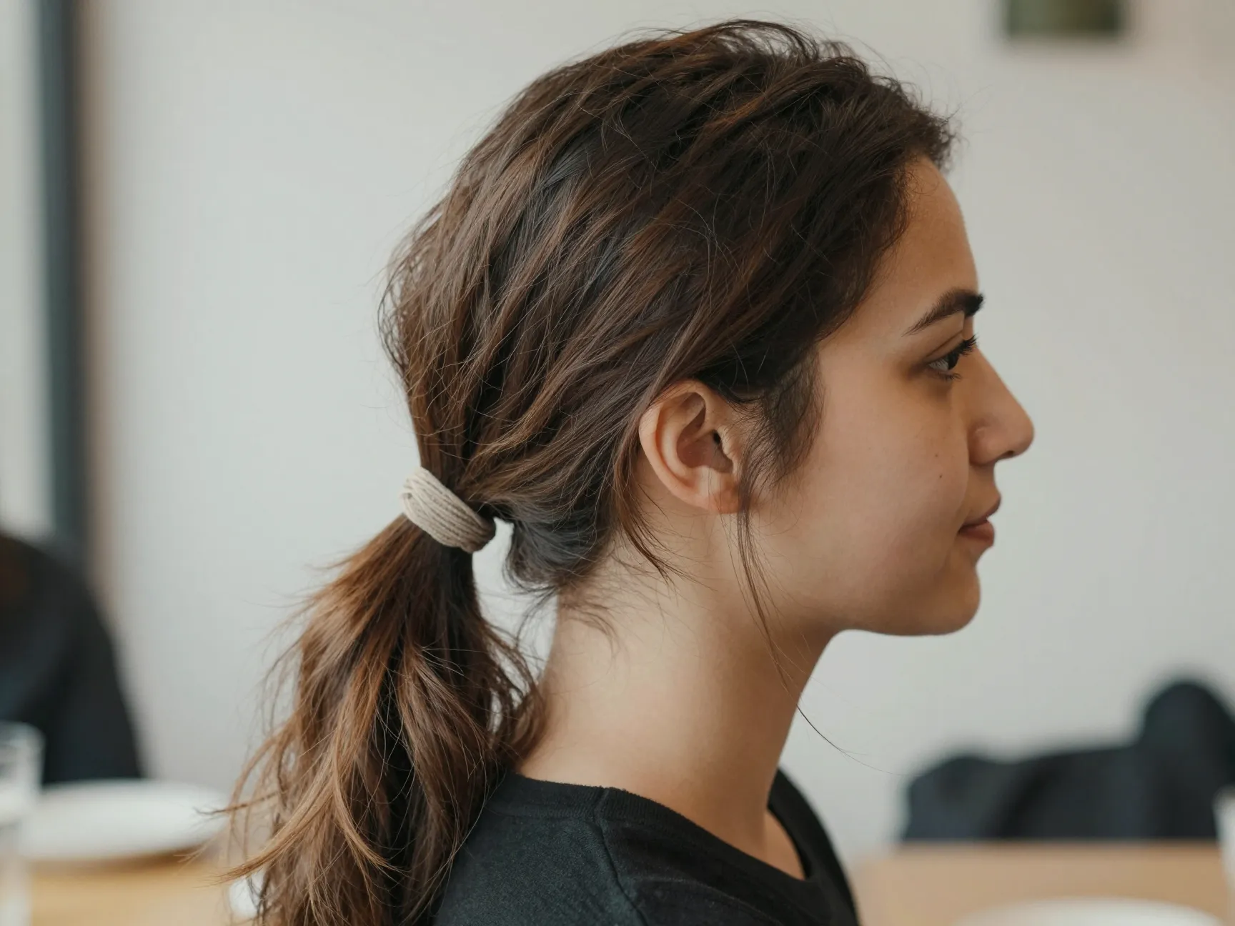 Classic tousled low ponytail on second day hair at casual brunch