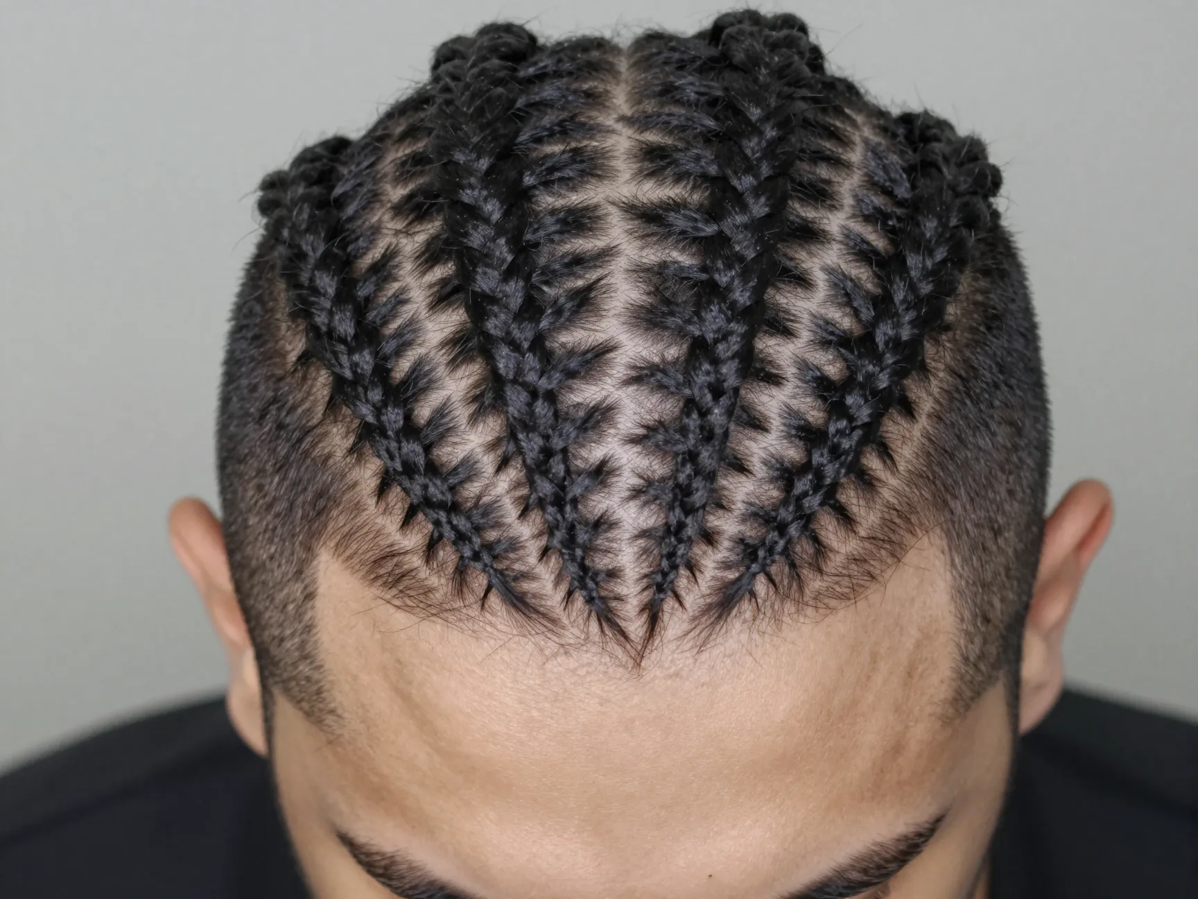 Zigzag part cornrows with mid fade artistic head pattern