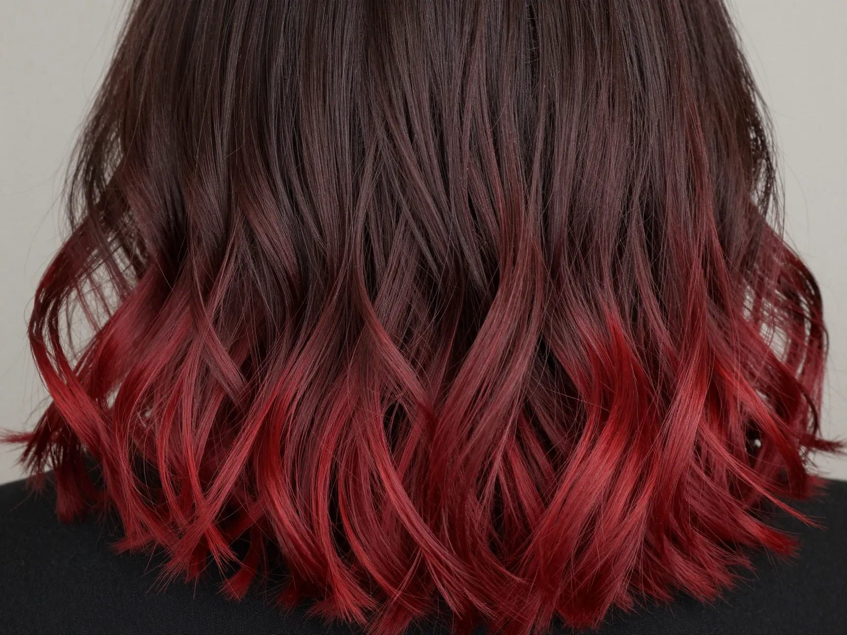 A woman with wavy shoulder length cherry mocha ombre gradient hair