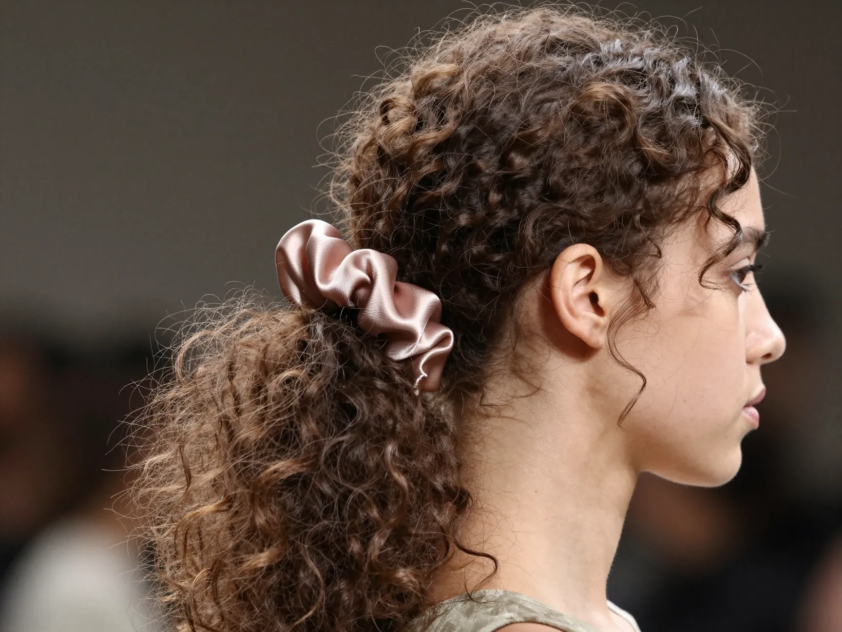 Runway ready fluffy low ponytail with intentional texture and silk scrunchie