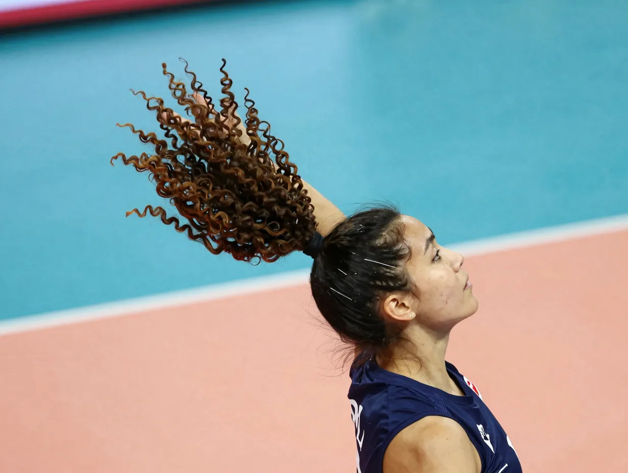 High ponytail with defined bouncy curls on volleyball court