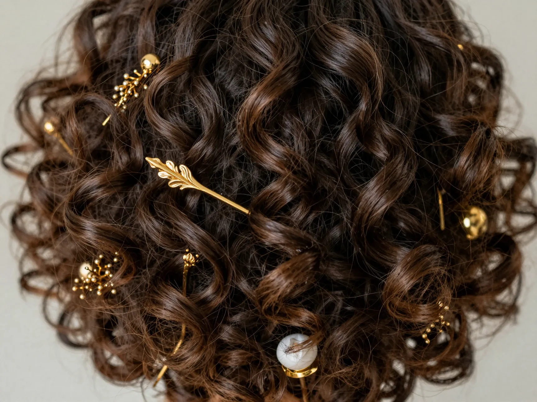 Natural coils with sculptural gold pins celebrating natural texture