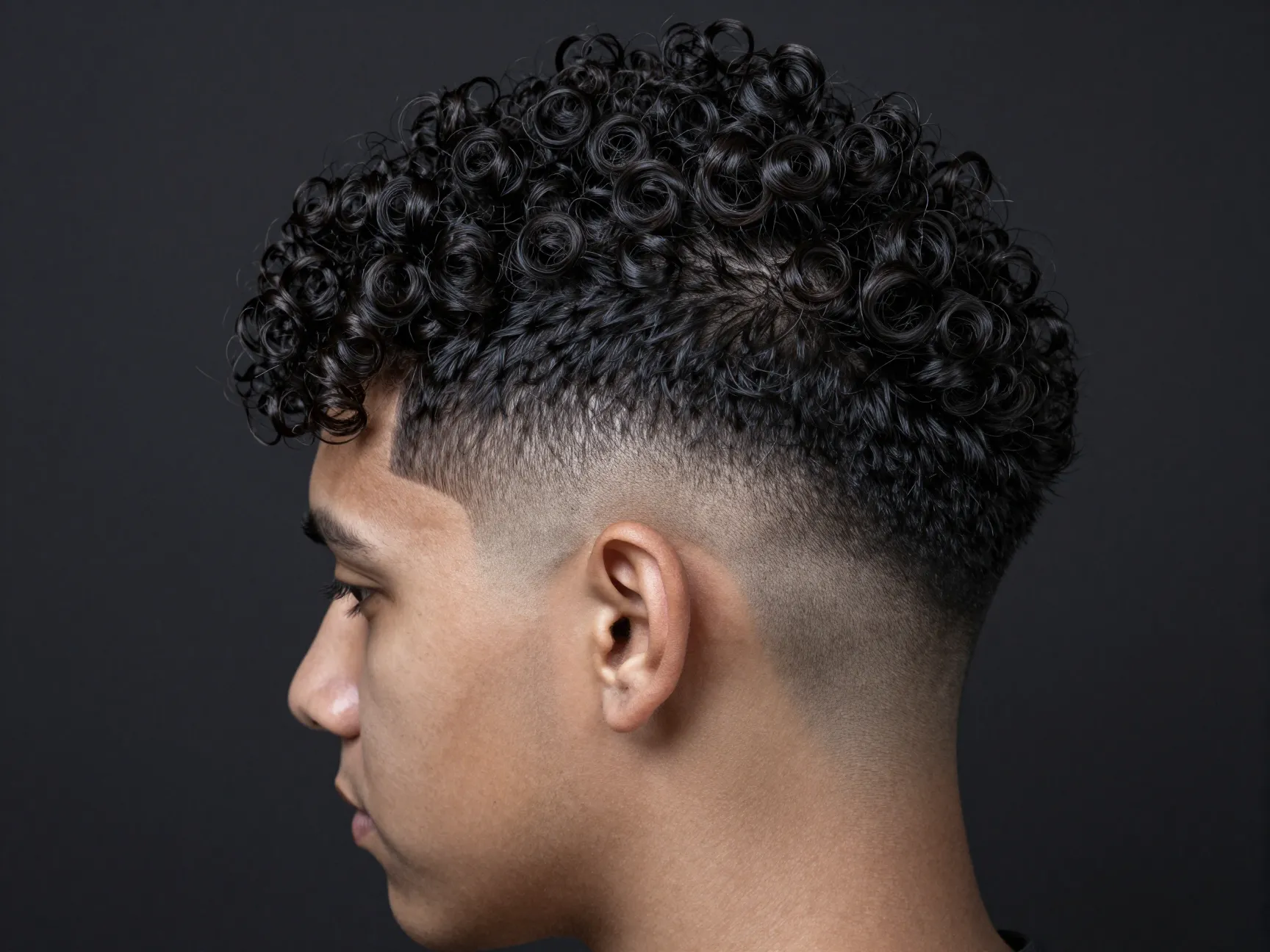 Curly hair fade with voluminous crown buzzed nape dramatic contrast