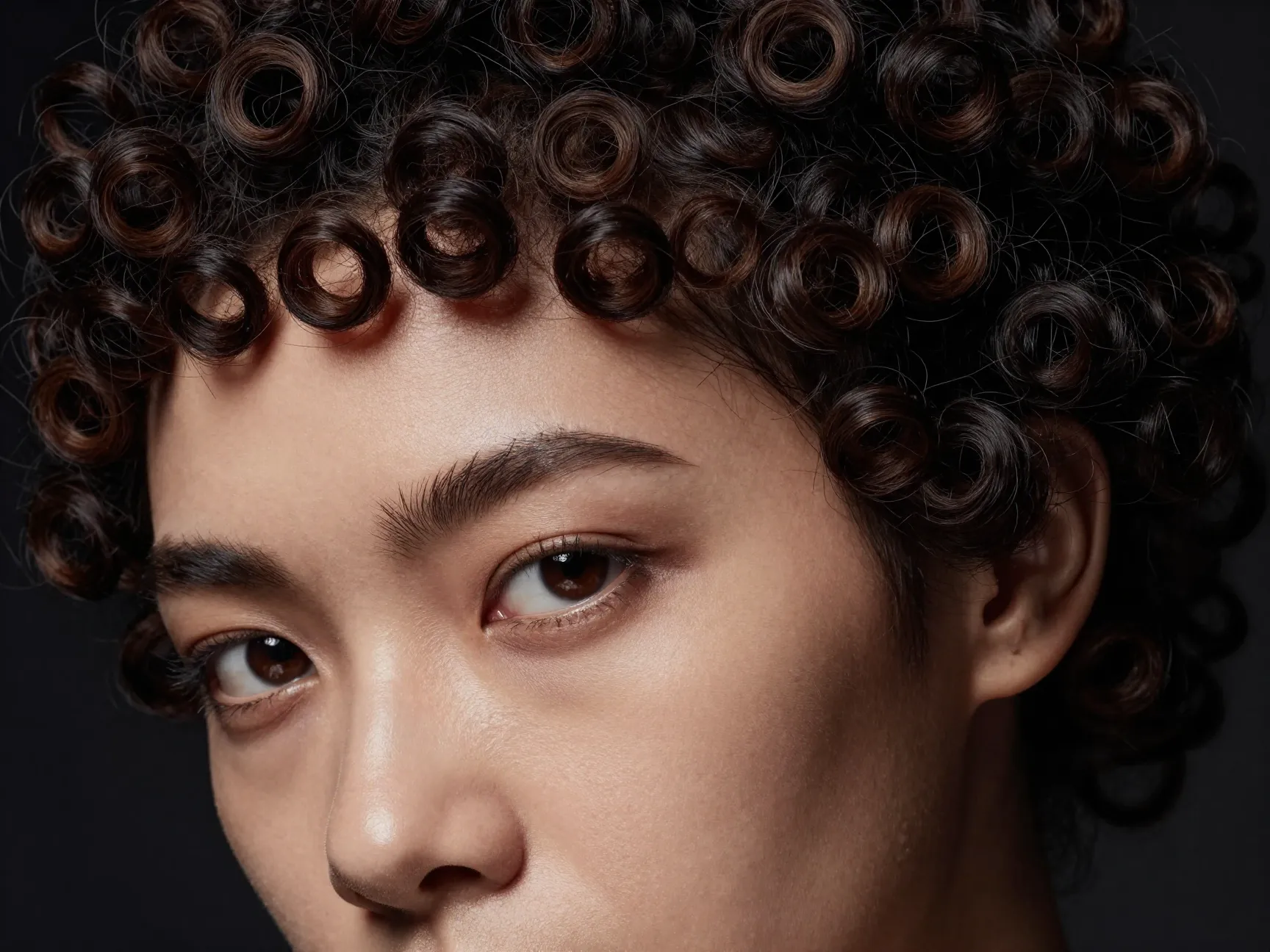 A woman with ultra short micro bangs on her tight curly hair