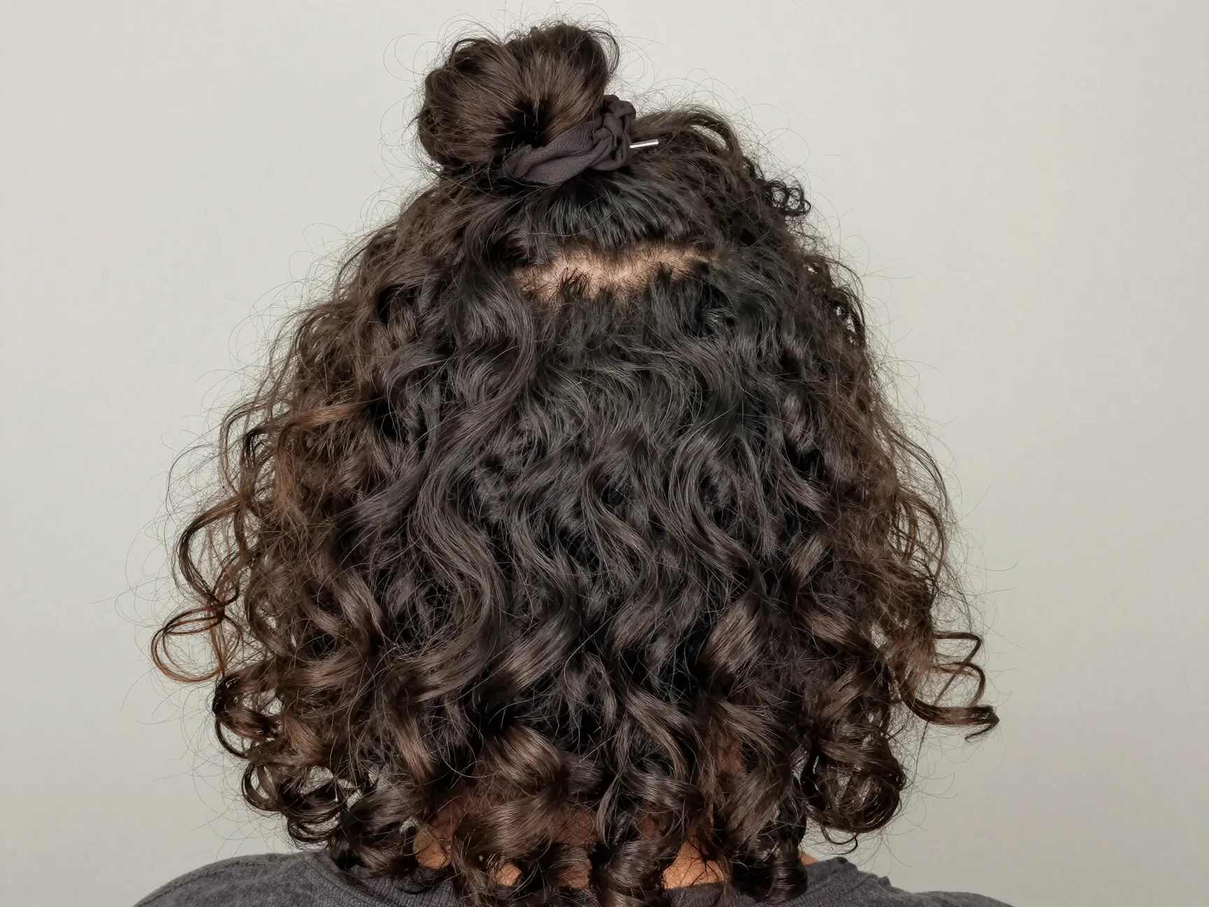 Half up half down curly hair style with top section secured